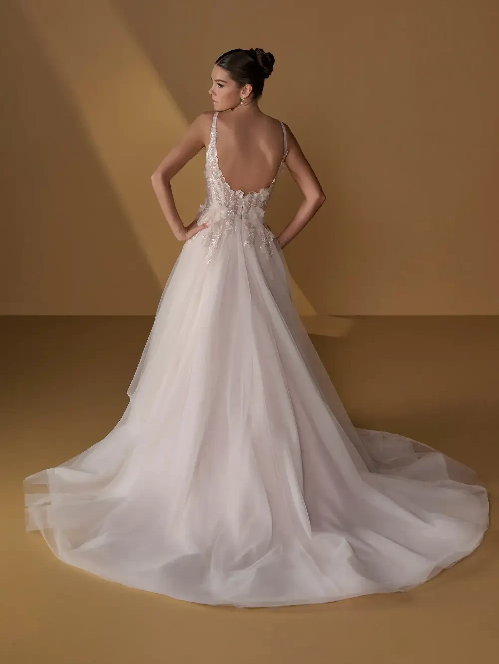 model is wearing an open back sleeveless a-line bridal gown