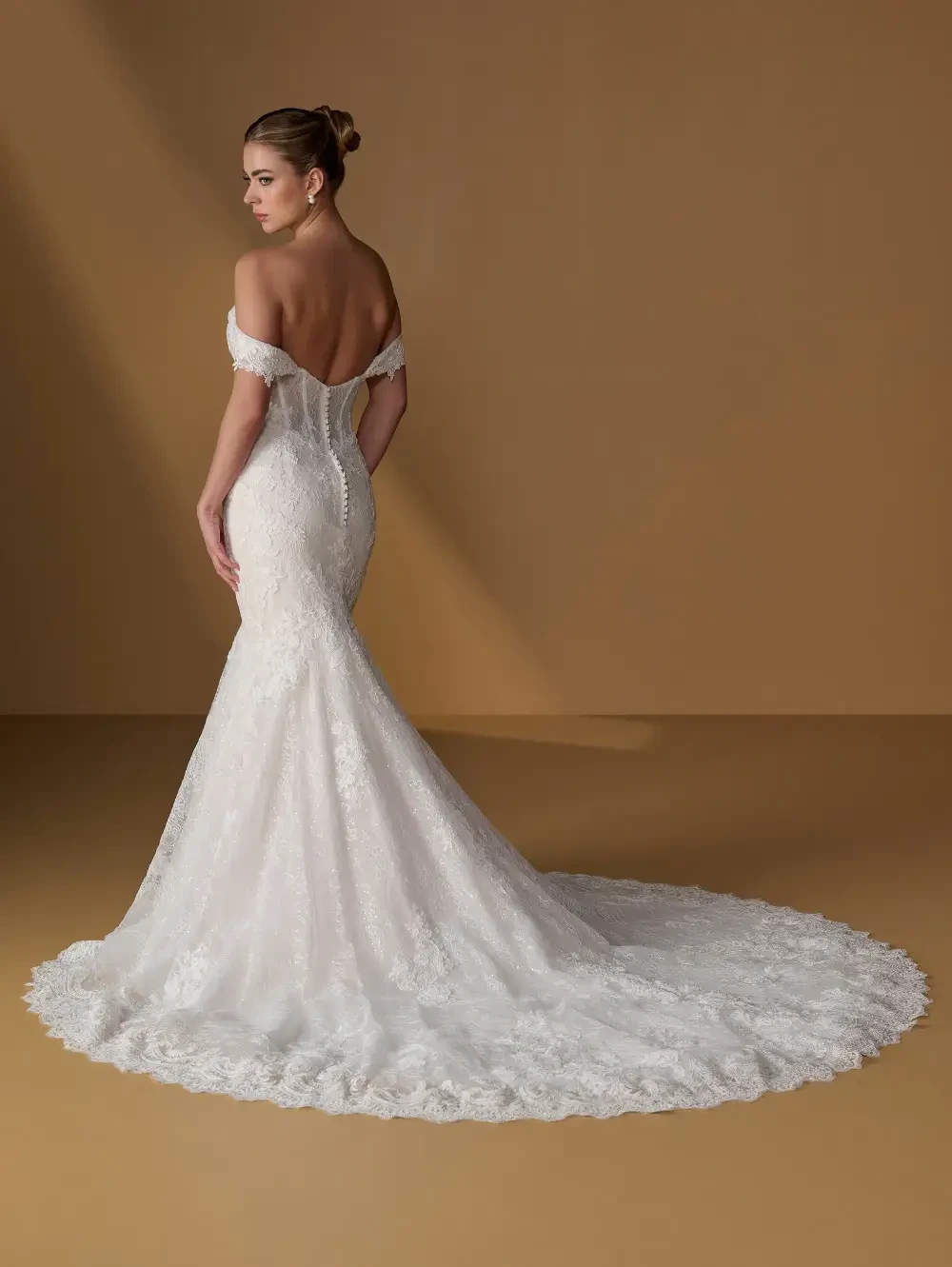 model is wearing an off the shoulder mermaid wedding dress