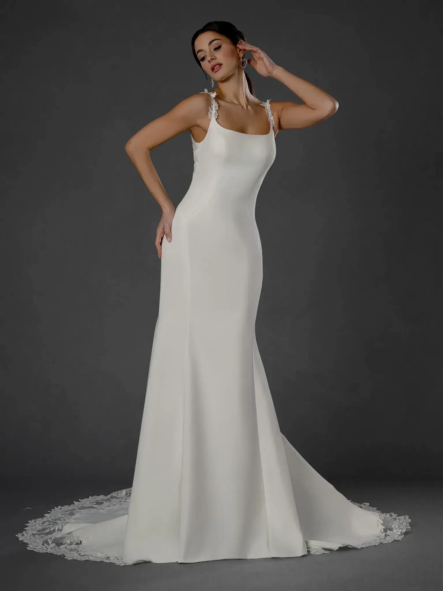 model is wearing a sleeveless fit and flare wedding dress with a low back