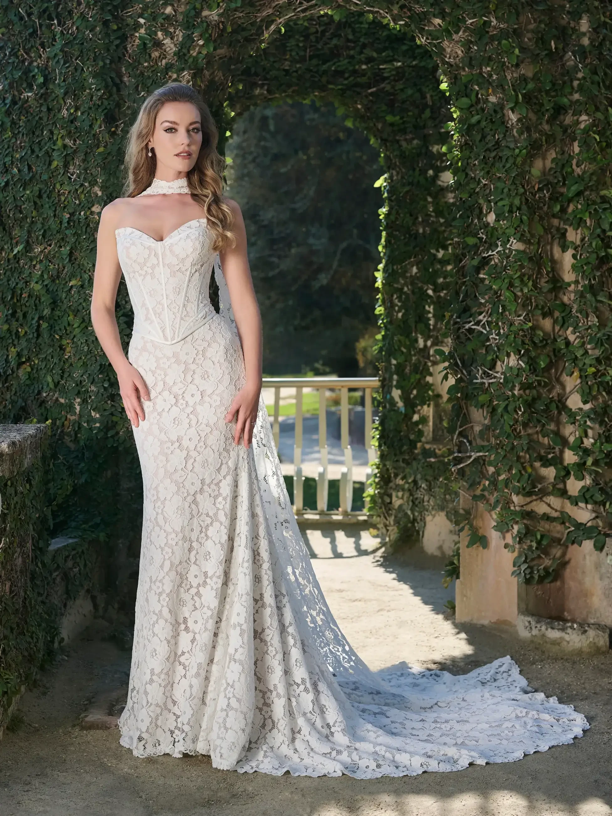 model is wearing a lace wedding dress with a basque waist