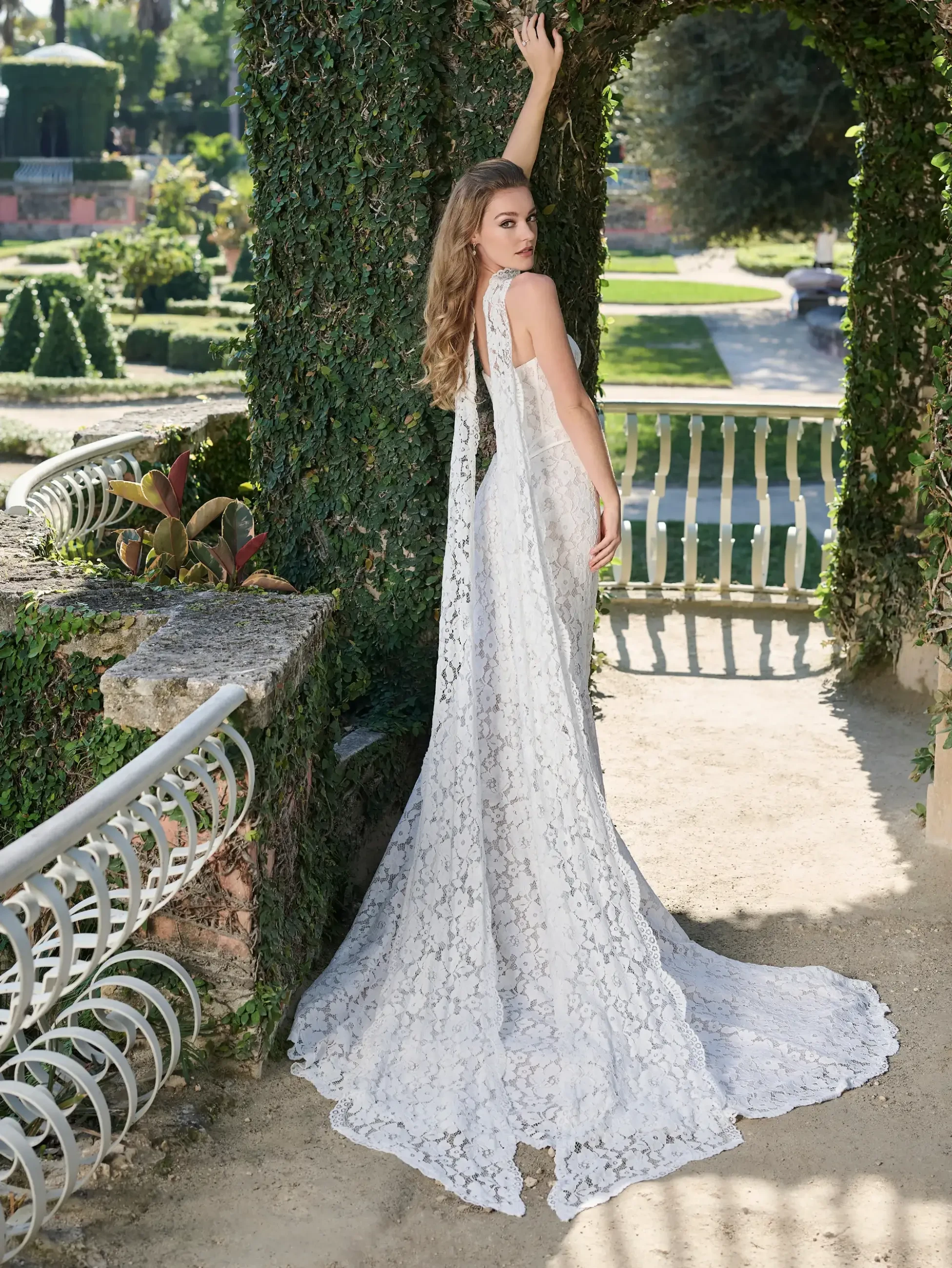 model is wearing a lace wedding dress with a basque waist