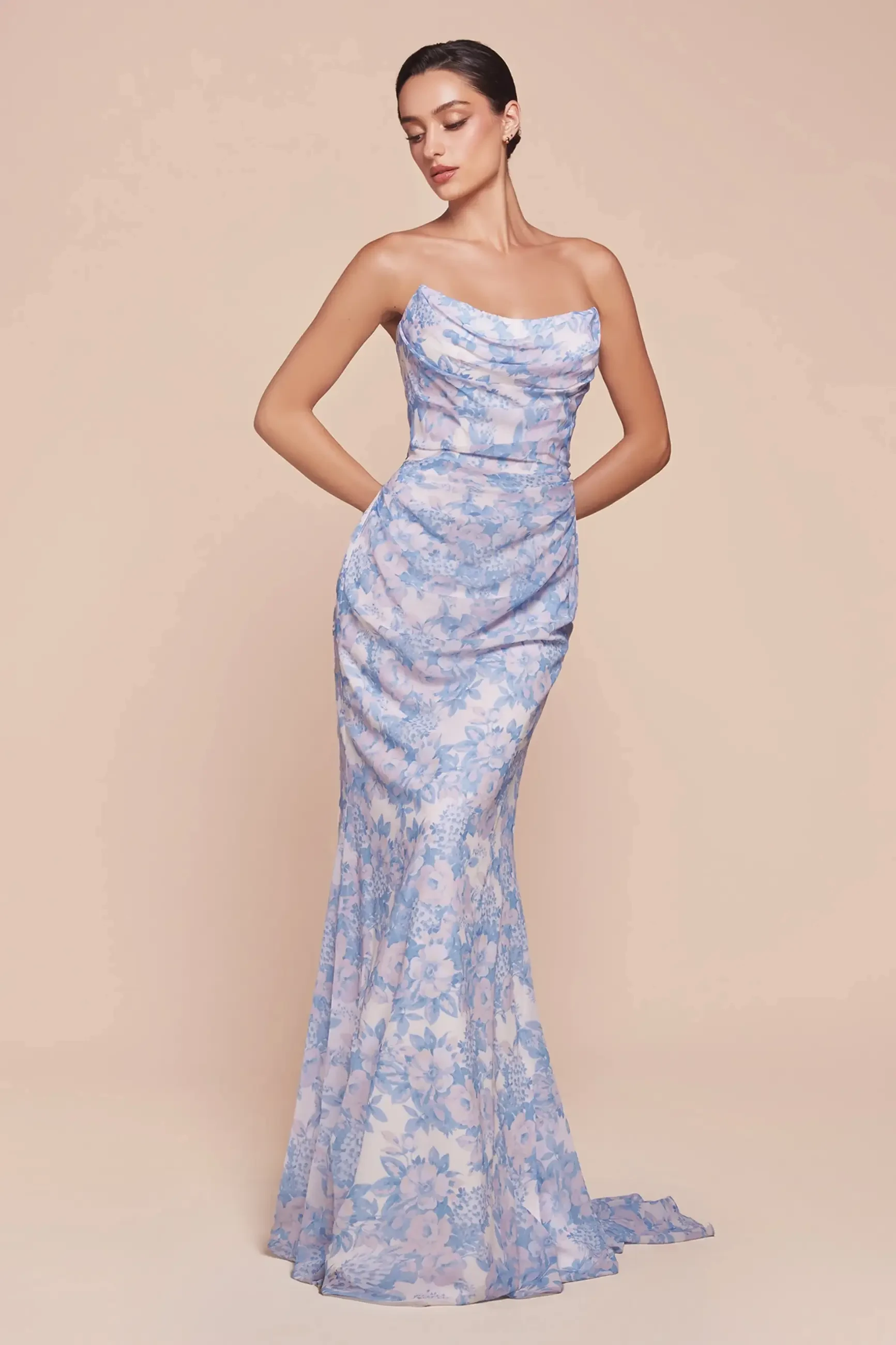 model is wearing a strapless blue floral bridesmaid dress